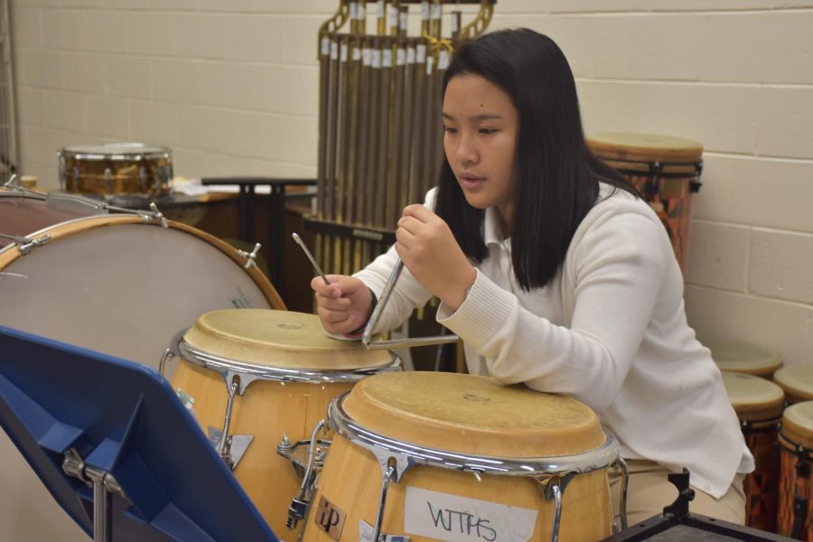 Juarez enjoys playing percussion in the school band. Here, she plays the triangle while reading music.