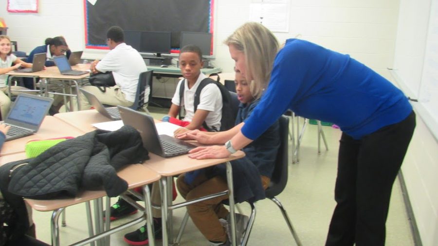 7th grade Social Studies teacher. Mrs. Donohue helps one of her students in her 2nd period class.
