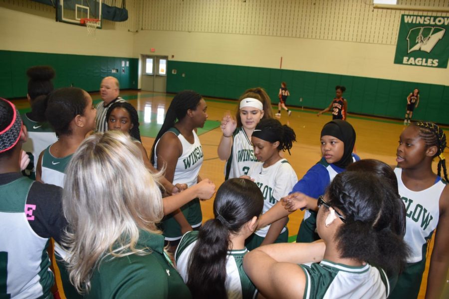 The team throws hands in for a cheer before going back out to take the court,