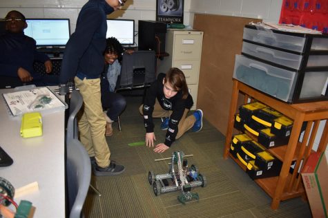 Members of the team test the robot to see if they can identify way to improve on their engineering design plan.