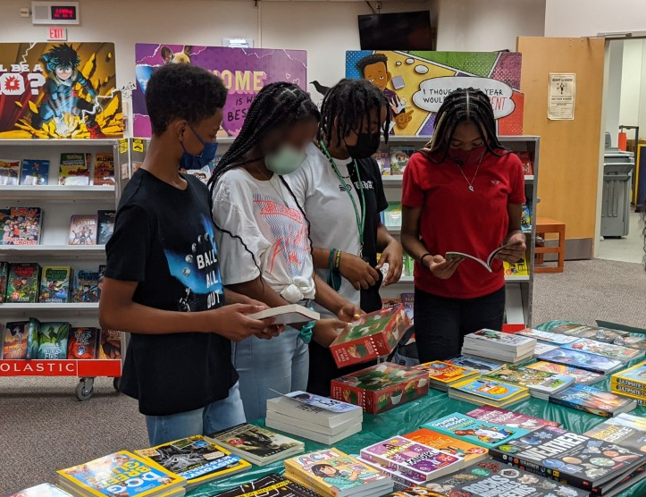 8th-grade students take a look at the selection of books at the book fair