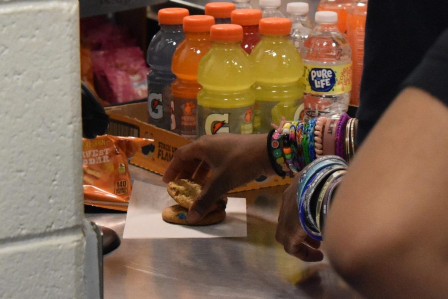 A student buys M&M cookies during lunch.